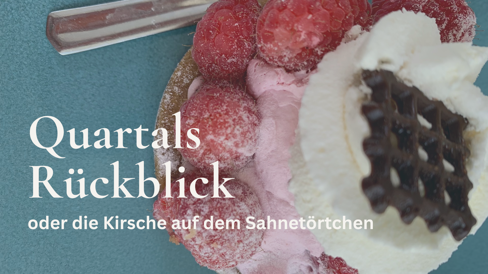 Nahaufnahme eines Himbeer-Sahnetörtchens auf einem türkis-farbenden Teller.