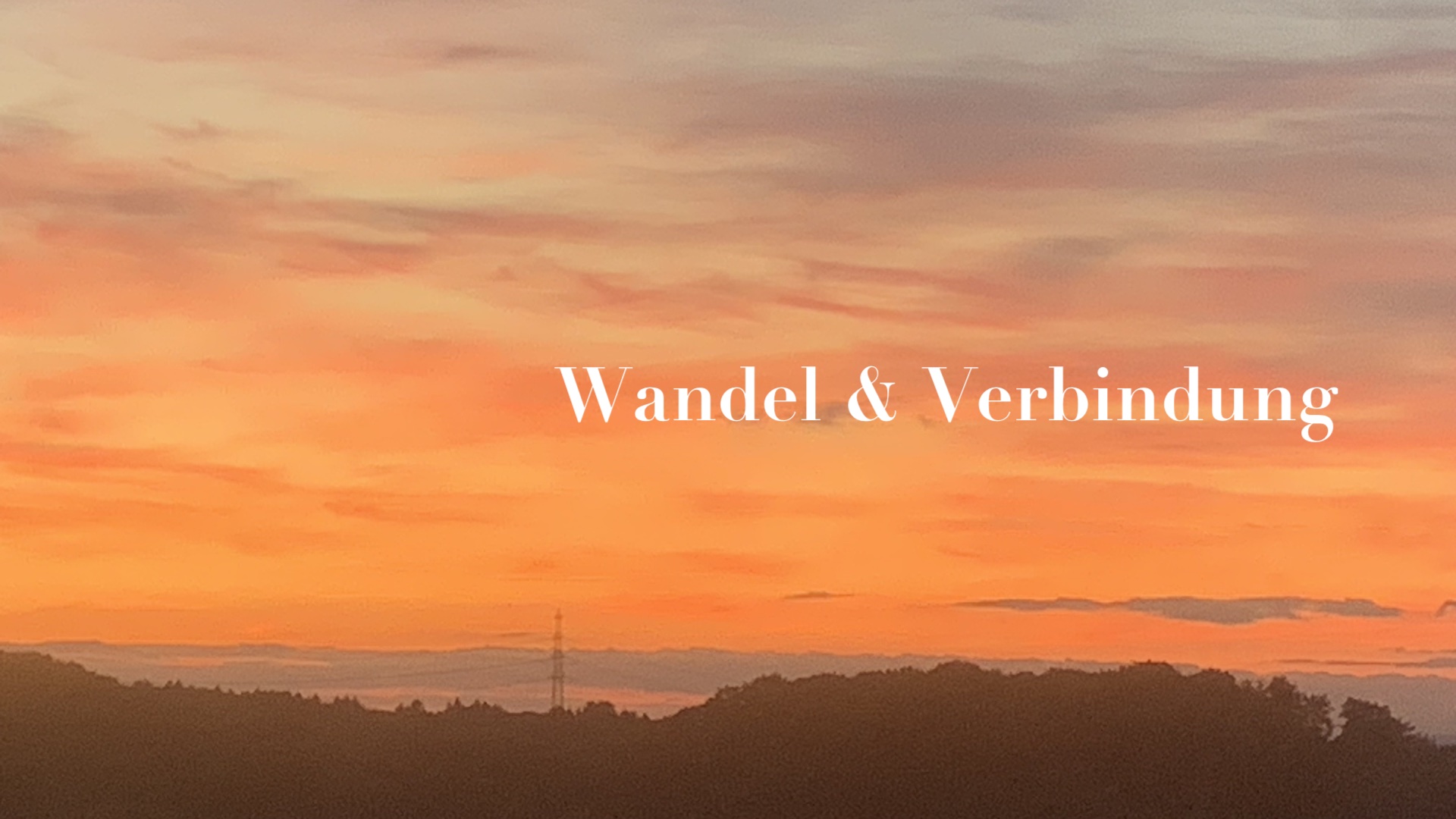 Sonnenuntergang, orangeroter Himmel udn ein Schriftzug Wandel & Verbindung