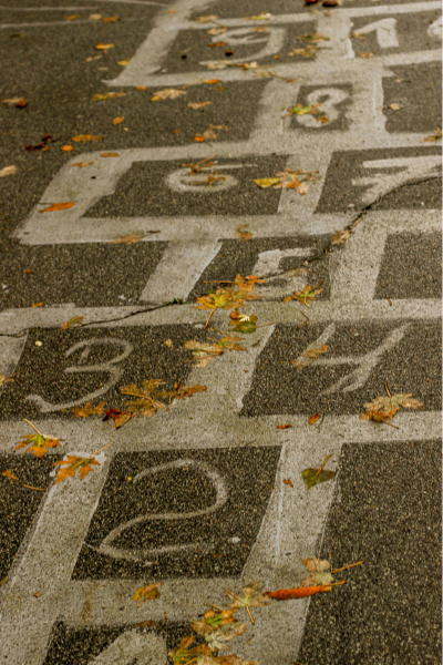 Ein auf den Asphalt gemaltes Hüpfspiel (Himmel und Hölle), das den Weg von einer Entscheidung zum nächsten Schritt symbolisiert.