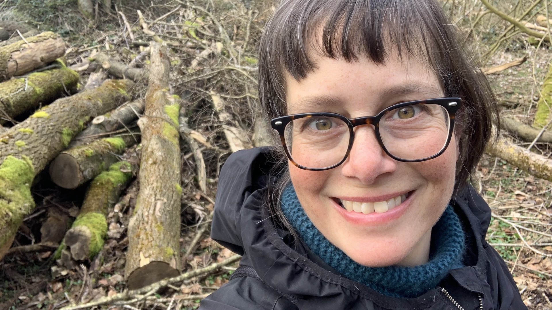 Portrait von Katja Reetz im Wald. Sie blickt direkt und konzentriert in die Kamera und strahlt die Ruhe und den Fokus aus, den der Blogartikel beschreibt.